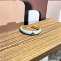 Primer plano detallado de un anillo vintage de esmalte azul claro con gema verde cuadrada. - Estilo gema verde cuadrada (11)