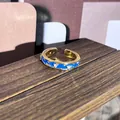 Vista macro de un anillo dorado estilo palacio con esmalte azul y piedras brillantes - Estilo decorado con strass azul (12)