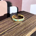 Vista macro detallada de un anillo ajustable de esmalte dorado vintage con montañas - Estilo textura de montaña azul-verde (13)