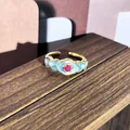 Elegante anillo de esmalte floral vintage en acabado dorado con gema rosa central. - Estilo Floral Palacio (n.º 38) / Base Azul con Rhinestone Rosa