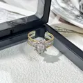 Primer plano de anillo vintage bicolor con halo de cristal ovalado y micro-pavé - Anillo ajustable estilo 2