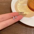 Elegant oval micro-inlaid crystal stud earrings presented in a warm cafe aesthetic. - Oval Style (E6418)