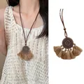 Retro ethnic long necklace with circular metal pendant and beige tassels on a model - Bohemian Disc Style (X1558 Brown A) / Brown