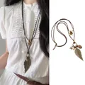 Detail of a retro bohemian feather necklace with ceramic beads on a long cord strap - Feather Star Style (X1624 Brown B)