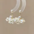 Close-up detail of elegant pearl petal earrings with golden hardware on a display stand. - Matte Petal Center Pearl Style (A2526金)