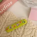 Macro view of Y2K style lime green hair clip with colorful heart and star rhinestones - Fruit Green