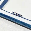 Detailaufnahme eines Silberrings mit blauen und weißen Zirkonia in einer Box - Dreiecks-Design (Nr. 1) / Silber