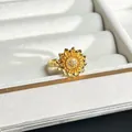 Detailed close-up of a gold 3D flower ring with crystals in a white jewelry box. - 3D Clustered Sunflower Style (No.1)