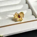Detail view of a luxury baroque gold flower ring with red gemstone and pavé stones - Three-Petal 3D Red Gemstone Style (No.2)