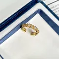 Makrodetail eines französischen goldenen Rings im Retro-Stil mit funkelnden Zirkoniasteinen - Einstellbar Offen / Vintage Blumenstil (4号)