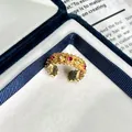 Detailaufnahme eines französischen Vintage-Goldrings mit roten und weißen Zirkonia-Steinen - Einstellbar Offen / Rot & Weiß Zirkonia Wellenstil (5号)