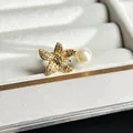 Detail view of 3D gold flower ring with pearl and sparkling crystals in jewelry box. - Asymmetric Pearl Pentagonal Flower Style (No.5)