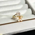Detailansicht eines goldenen Ringes mit zwei eleganten 3D-Blumen aus Kristall und Katzenauge. - Opal Textur Doppelblume Stil (Nr.7)