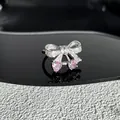 Gros plan sur une bague nœud élégante avec cristaux de cœur roses et micro-pavé - Style 3