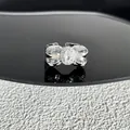 Gros plan d'une bague nœud en argent avec un cristal ovale scintillant au centre - Style 4