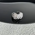Vue détaillée d'une bague nœud argentée étincelante avec pierre ovale sur surface noire. - Style 6