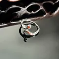 Macro view of minimalist silver snake ring with red enamel detail on reflective base - Red-Eyed Snake Style (20号)