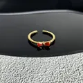 Bague ouverte dorée ajustable élégante avec un détail de nœud rouge et anneau texturé - Style 10