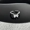 Vue détaillée d'une bague ouverte en forme de nœud argenté avec oxydes de zirconium - Style 12