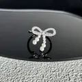 Vue détaillée d'une bague nœud argentée avec pavé de zircons et perles blanches délicates. - Style 13