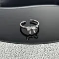 Gros plan d'une bague nœud argentée élégante ornée de pierres de zircone brillantes - Style 14