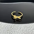 Détail d'une bague nœud dorée ajustable avec des accents de zircon étincelants - Style 20