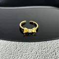 Vue rapprochée détaillée d'une élégante bague nœud dorée avec des cristaux cœur jaunes - Style 21