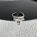 Détail d'une bague nœud papillon argentée avec pierre rose et cristaux pavés étincelants - Style 25