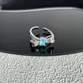 Gros plan sur une bague noeud en argent avec une pierre bleue ovale - Style 28