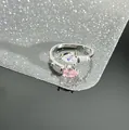Close-up of a silver-toned open ring featuring pink and white pear-shaped cubic zirconia. - Dual Water Drop Pink Clear (Style 1)