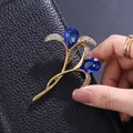 Elegant gold-toned floral brooch featuring deep blue teardrop crystals and pavé stones. - Dark Blue Teardrop Crystal Streamline Flower Style (XD824398-1)