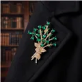 Elegant gold-tone bouquet brooch with emerald green teardrop crystals on a black coat - KC Gold Green Bouquet Glass