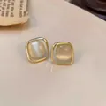 Detailed shot showing the golden square frame and cat-eye stone texture of the earrings. - Square Cat's Eye Stud Earrings (E2586 Gold)