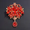 Vintage gold-toned alloy brooch featuring vibrant red crystals and a large glass teardrop - Red