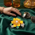Eleganter gelber Pfingstrosen-Brosche mit Emaille und Kristallen auf grünem Satin. - Gelb