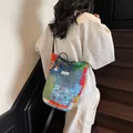 Colorful patchwork canvas bucket bag with adjustable shoulder strap and drawstring. - Blue