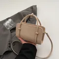 Elegant minimalist beige Boston bowling handbag with top handles and shoulder strap. - Apricot