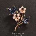 Elegant floral brooch with blue crystals and pearls, gold-finish, size 4.5x4.5cm. - Plum Blossom Branch Style (XD8296-1)