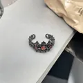 Vue détaillée d'une bague gothique noire avec une pierre précieuse rouge en forme de cœur - Motif Cœur (N° 1)