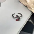 Detaillierte Makroaufnahme eines gotischen schwarzen Metallrings mit rotem Mondakzent - Sichelmond Stil (Nr. 7)