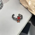 Nahaufnahme eines schwarzen Punk-Rings mit birnenförmigen roten Edelsteinen, Detailansicht - Skelett Birne Stil (Nr. 9)