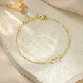 Detail shot of a dainty gold-plated titanium steel chain bracelet with a letter E charm. - Letter E Style / Gold