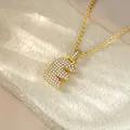 Macro view of a gold-plated iced-out letter E pendant necklace with sparkling crystals. - Letter E / Champagne Gold