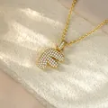 Detailed view of a gold hip-hop pendant necklace with pave-set stones in the shape of letter F - Letter F / Champagne Gold