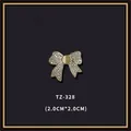 Vue détaillée d'une broche noeud doré avec pierre oeil de chat et strass étincelants - Style Papillon en Strass Œil-de-chat (TZ-328)