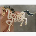Detailed close-up of a stylish gold-tone horse brooch with white enamel inlay - Horse Style (XD825269)