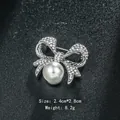 Elegant silver-plated bow brooch adorned with a white pearl and sparkling rhinestones - Bowknot Shape (XD6408) / Silver