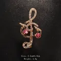 Elegant musical note brooch with pink crystals and clear rhinestones in gold tone finish - Gold / Pink Rhinestone