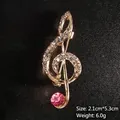 Elegant gold musical note brooch with sparkling rhinestones and pink crystal accent - Gold/Pink Stone
