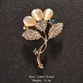 Elegant gold-tone floral brooch pin featuring cat eye stones and sparkling crystals - Floral Core Design (XD9174)